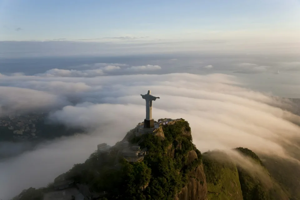 High angle view of colossal Christ Redeemer statue surrounded by clouds, Corcovado, Rio de Janeiro,